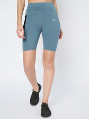 Woman posing side-profile in Waylene's light blue high-waist cycling shorts, showcasing the streamlined fit and mid-thigh length, complemented by black sneakers.