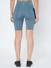Rear view of a woman wearing Waylene's light blue high-waist cycling shorts, highlighting the snug waistband and smooth silhouette, paired with black athletic shoes.
