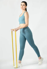 Waylene's airforce blue women's track suit featuring a fitted tank top and high-waisted leggings, model holding a yellow measuring tape, showcasing a side view, with white sneakers.