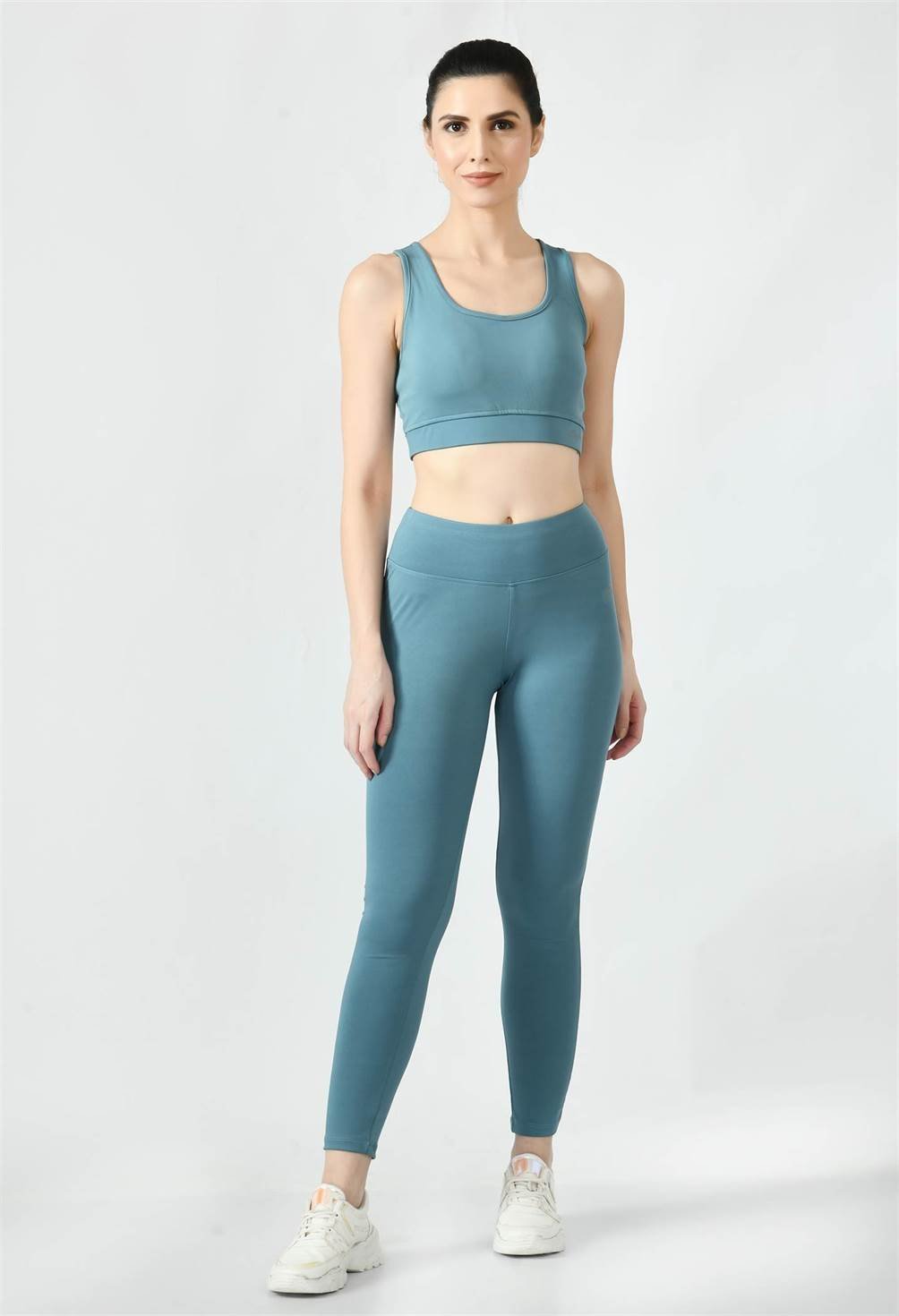 Waylene's airforce blue women's track suit with a sleek tank top and matching leggings, model standing straight facing the camera, paired with white sneakers.