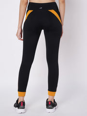 Waylene black and orange sports leggings with mesh panels, back view