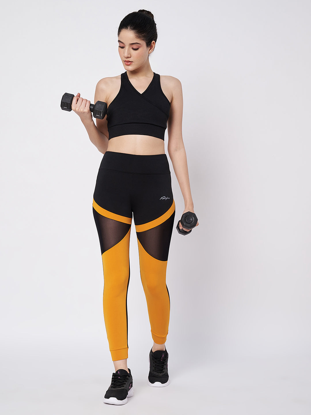 Waylene black and orange sports leggings with mesh panels, workout pose