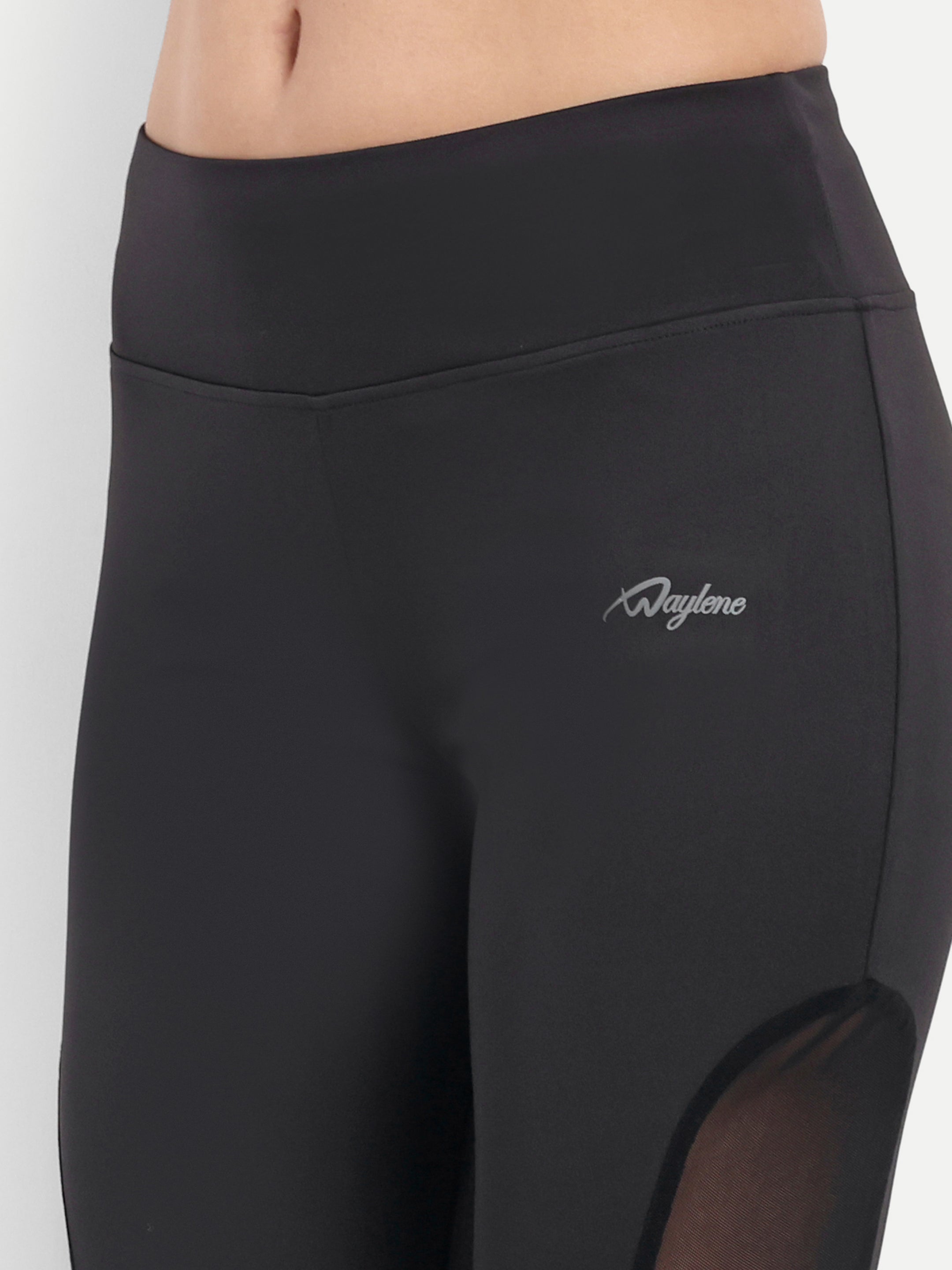Detailed view of Waylene's black Capri with a focus on the waistband and mesh panel. The image highlights the snug fit and stretchable fabric, ideal for fitness enthusiasts.