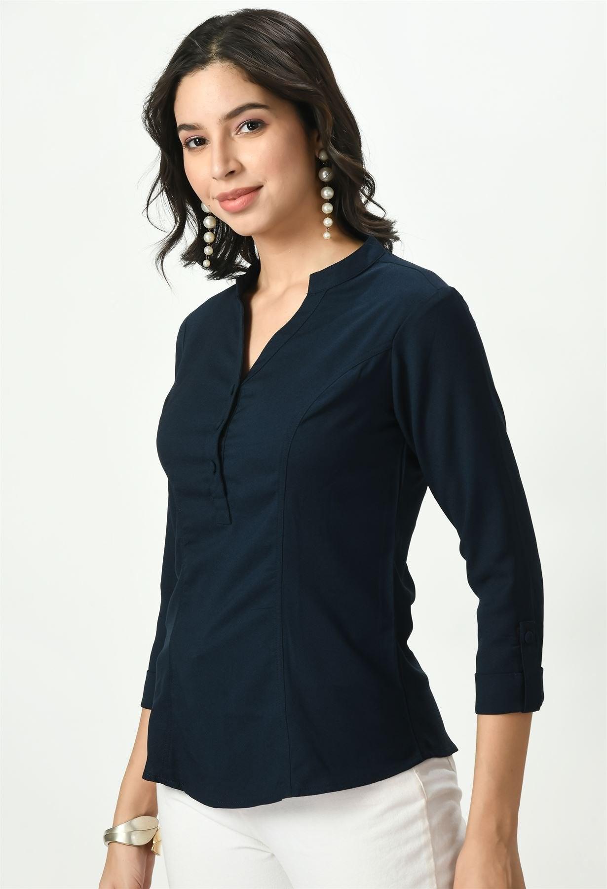 A woman in a three-quarter pose wearing a dark navy blue Waylene button-up top, styled with a V-neckline and cuffed sleeves.